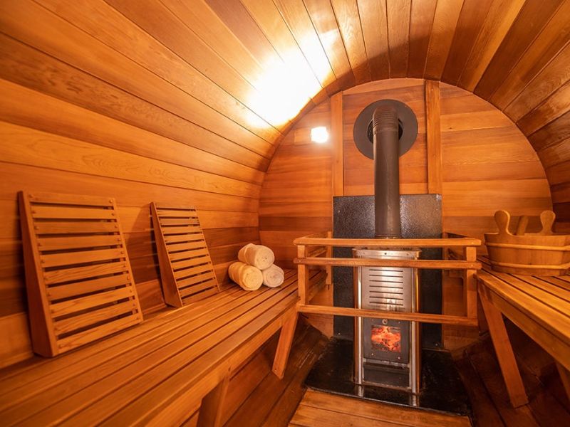 Cedar sauna interior with heater and rocks ready for a session
