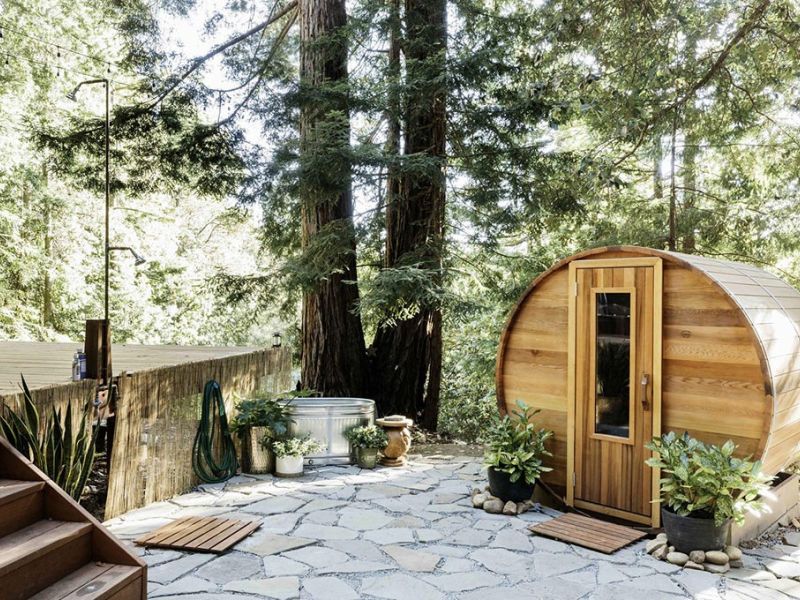 Outdoor cedar barrel dry sauna set in a garden